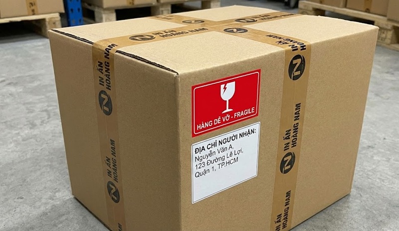 Kiện hàng in ấn được dán tem cảnh báo hàng dễ vỡ trước khi gửi đi.