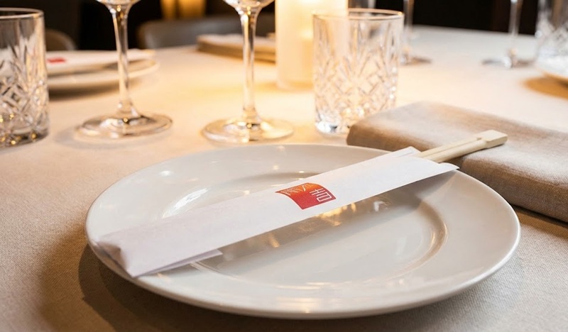 Setup bàn tiệc nhà hàng sang trọng với bao đũa in logo thương hiệu.