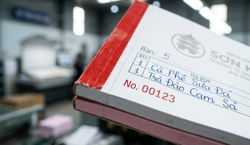 Cận cảnh gia công đường cấn răng cưa và in số nhảy màu đỏ trên phiếu order 2 liên.